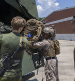 A U.S. Marine with 2nd Air Naval Gunfire Liaison Company, II Marine Expeditionary Force Information Group, loads his gear alongside Swedish service members during exercise Burmese Chase 25, at Marine Corps Base Camp Lejeune, North Carolina, July 27, 2025. Burmese Chase is an annual U.S. led, multi-lateral training exercise comprised of integrating ground and air fires, infantry tactics and naval gunfire alongside NATO allies to enhance combat readiness and interoperability. (U.S. Marine Corps photo by Cpl. Marc Imprevert) (This photo has been altered for security purposes by blurring out faces.)